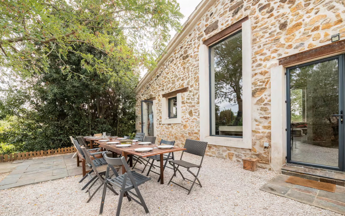 Loft d'Oc — Terrasse en pierre et grande table en bois sous l'arbre